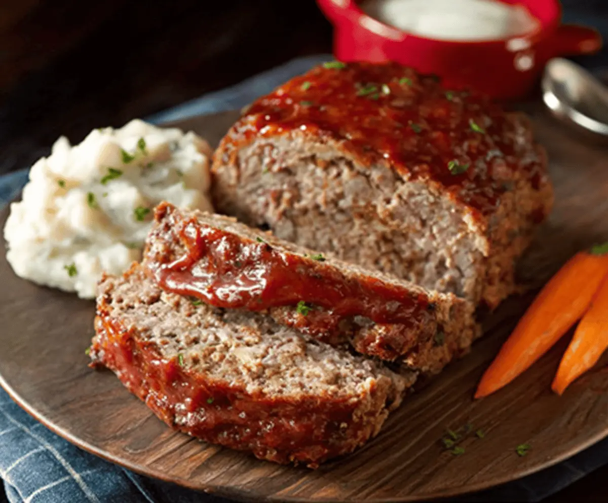 Delicious homemade ranch meatloaf topped with fresh herbs and served with mashed potatoes and vegetables