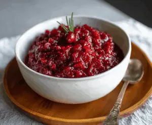 No Cook Cranberry Sauce in a bowl with fresh cranberries and orange zest for a quick holiday treat