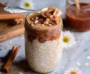 Delicious brown sugar cinnamon overnight oats served in a jar with fresh fruit garnish