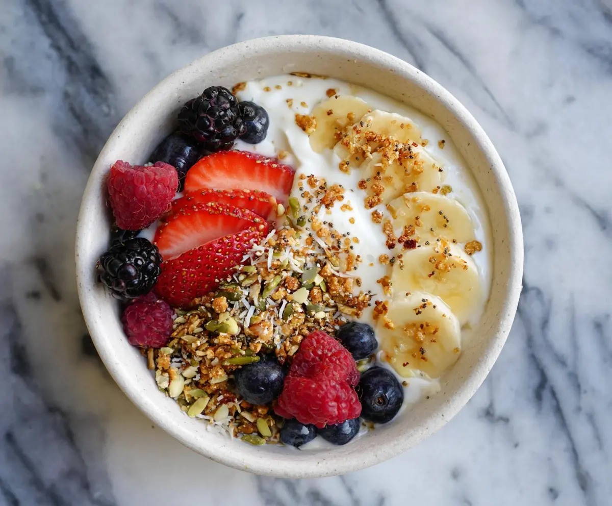 Healthy protein yogurt bowl topped with fresh berries and granola, perfect for a nutritious breakfast.