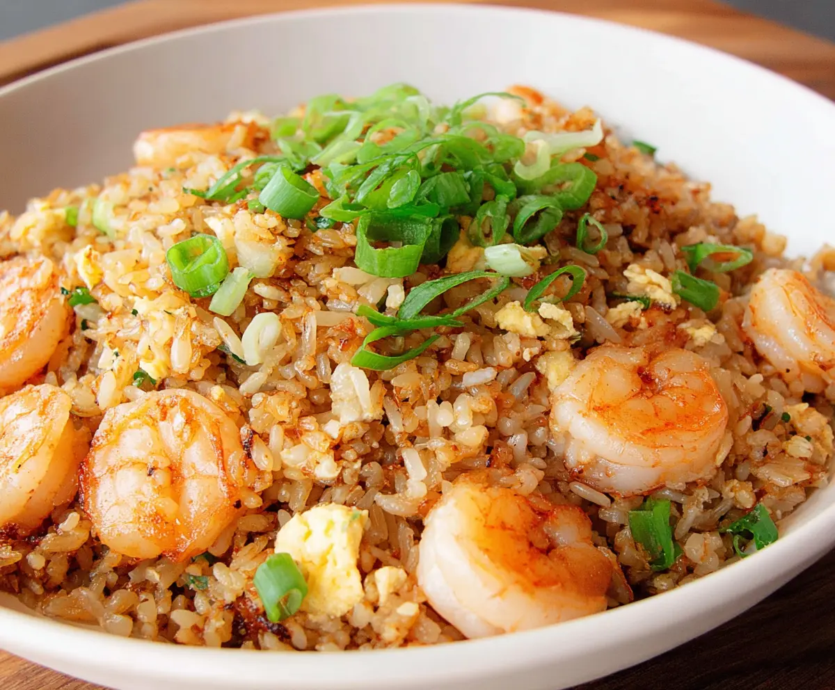 Delicious shrimp garlic fried rice served in a white bowl with garnishes