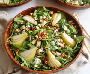 Fresh arugula and sliced pears in a vibrant salad bowl, perfect for a healthy meal.
