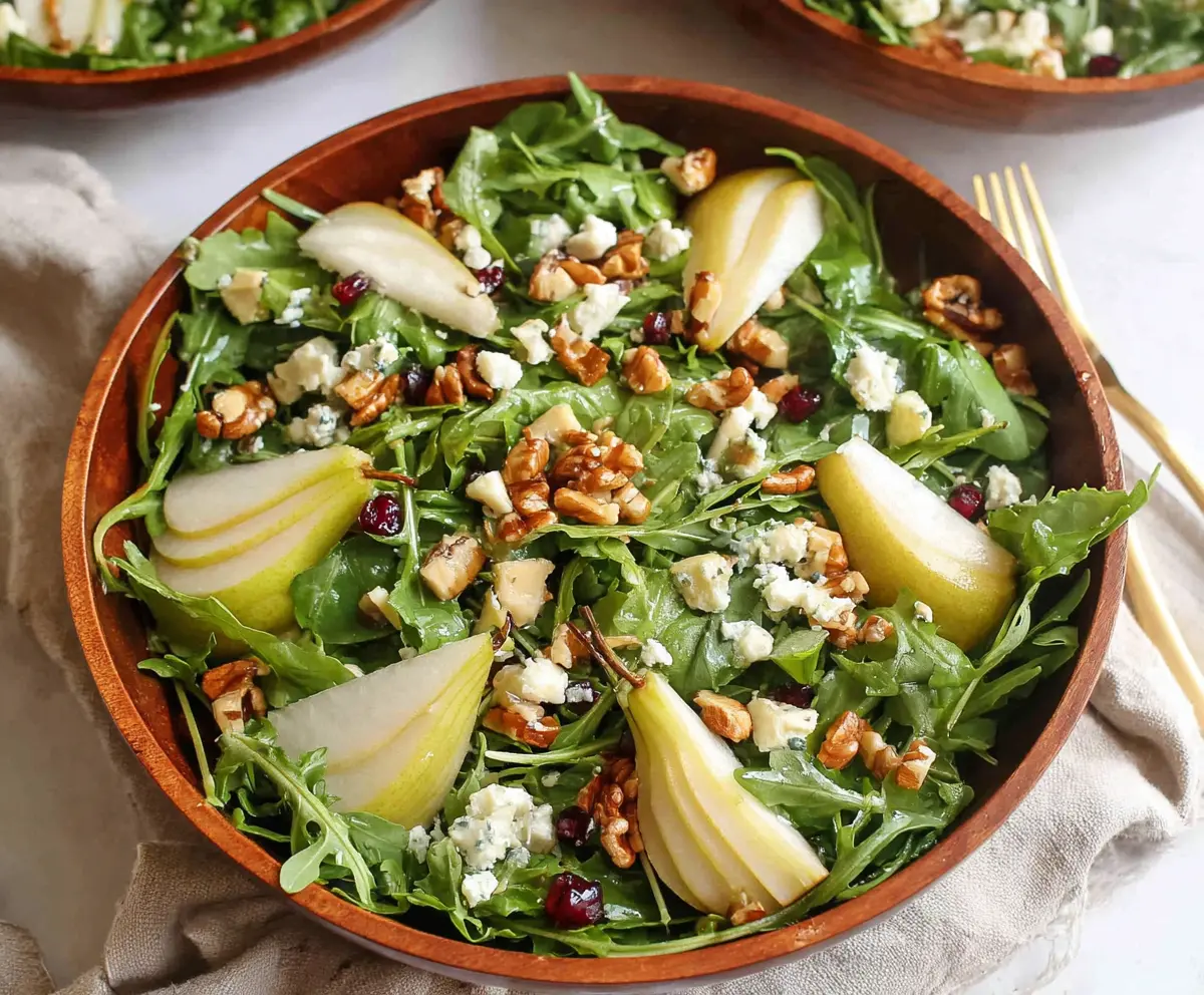 Fresh arugula and sliced pears in a vibrant salad bowl, perfect for a healthy meal.