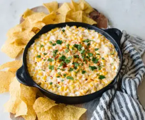 Cream Cheese Corn Dip served in a bowl with fresh herbs, perfect for summer parties and appetizers.