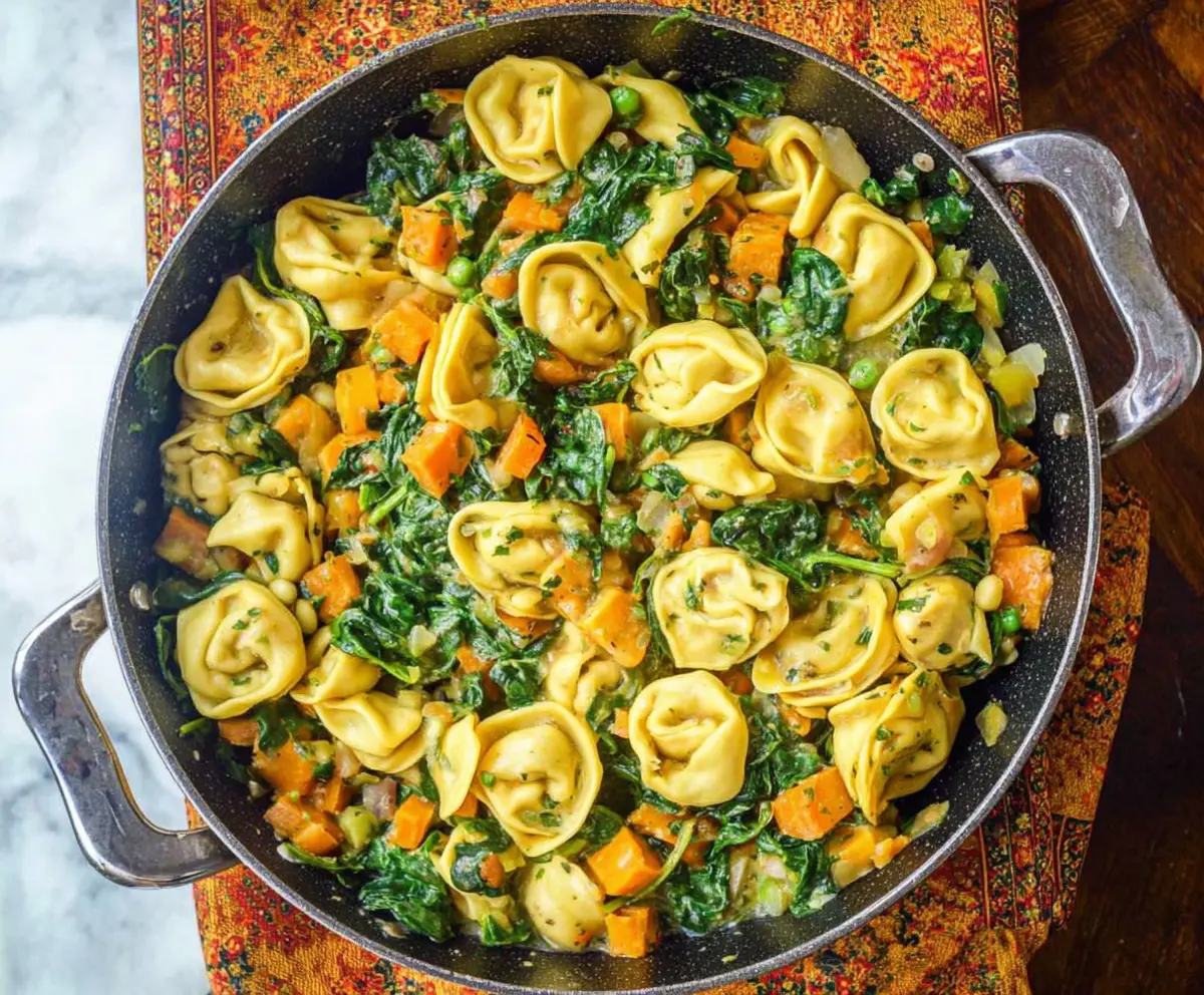 Delicious skillet tortellini with sweet potato and fresh spinach served in a rustic skillet