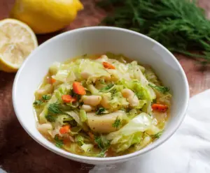 Refreshing Lemon Dill Cabbage Soup in a bowl, with fresh dill and lemon slices on top